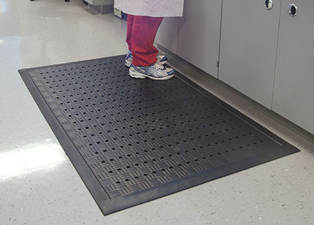 Healthcare professional standing on an anti-fatigue mat