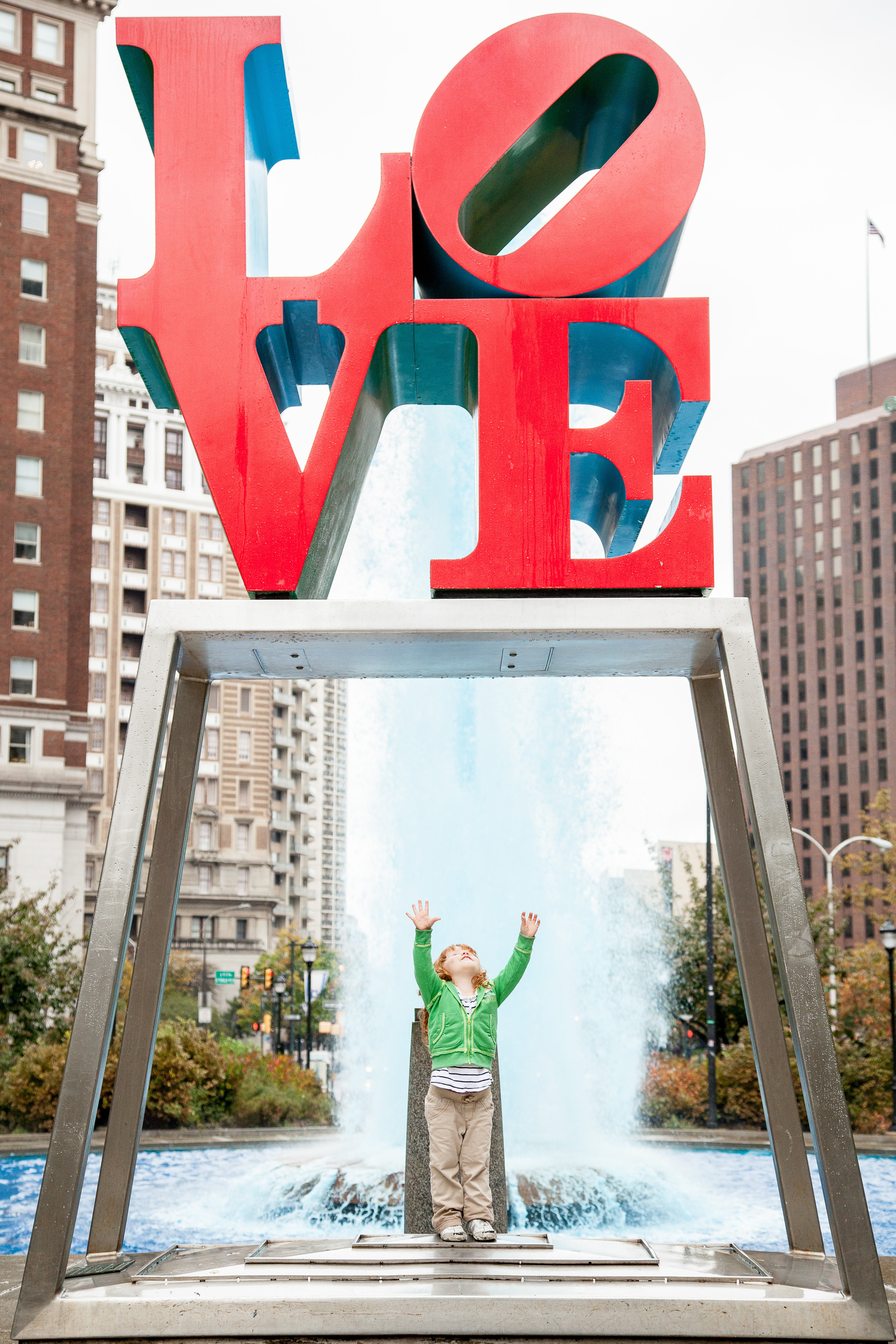 A young girl stands beneath Philadelphia’s iconic “LOVE” statue.